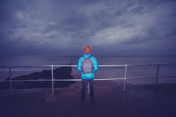 嵐の日に、海のそばに立ってハイカー — ストック写真
