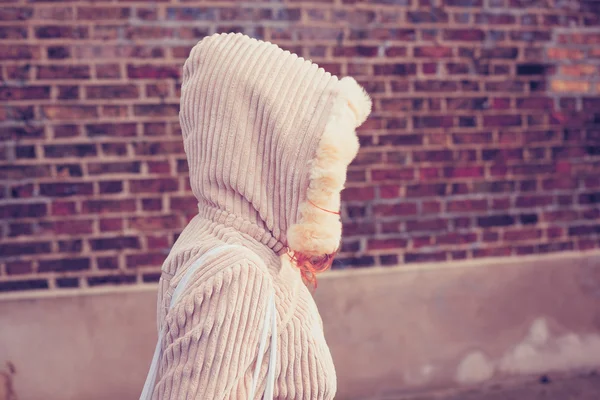 Jonge vrouw dragen van een kap boven in de straat — Stockfoto