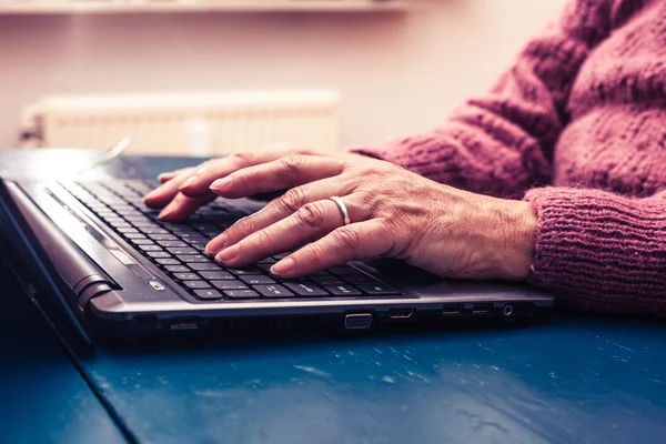 Gammal kvinna som arbetar på bärbar dator hemma — Stockfoto