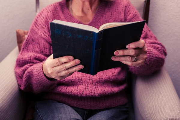 歳の女性が家庭で読書 — ストック写真