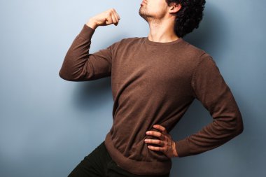 Young man in proud stance with fist raised clipart
