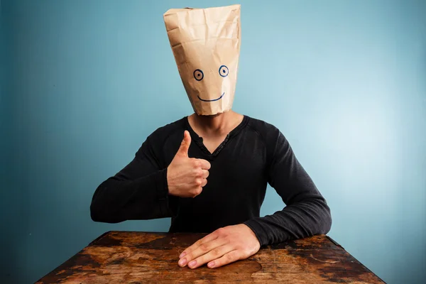 Man with bag over head giving thumbs up — Stock Photo, Image