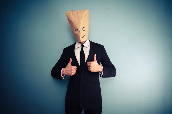 Businessman with bag over head giving two thumbs up — Stock Photo, Image