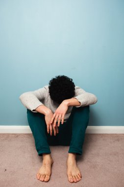 katta oturan üzgün bir adam