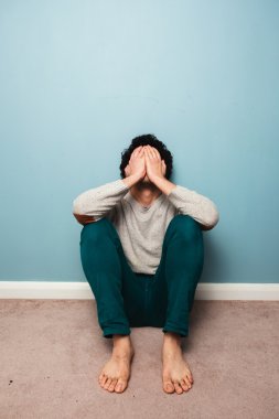 katta oturan üzgün bir adam