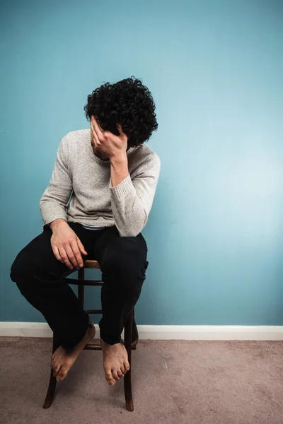 Verdrietig man zit op een stoel — Stockfoto