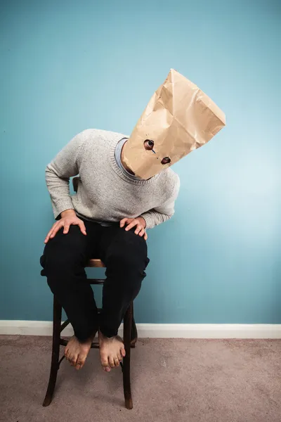 Mann mit Tasche über Kopf auf Stuhl — Stockfoto