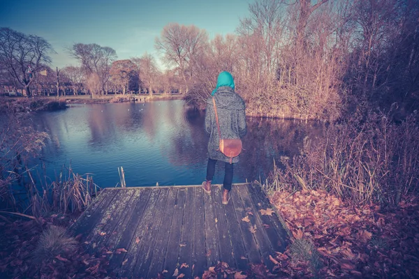 Giovane donna da stagno in autunno — Foto Stock