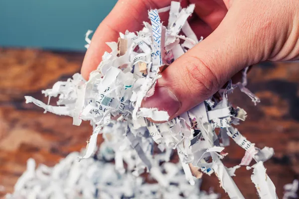 Mão com papel desfiado — Fotografia de Stock