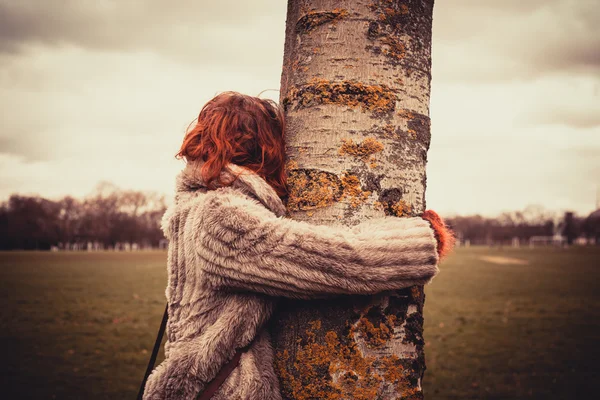 Vrouw een boom knuffelen — Stockfoto