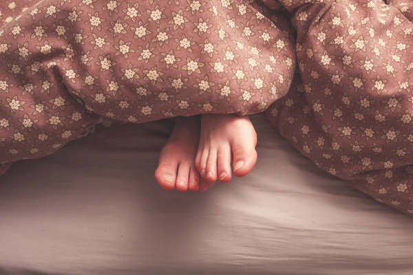 Pés de mulher na cama — Fotografia de Stock