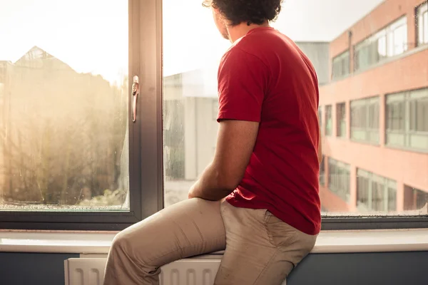 Junger Mann auf Fensterbank — Stockfoto