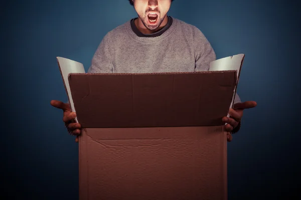 Surprised young man opening exciting box — Stock Photo, Image