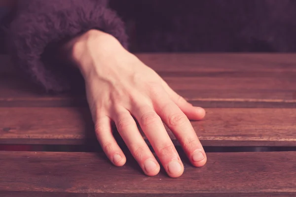 La mano de la mujer en la mesa — Foto de Stock