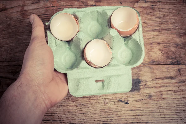 Mão segurando uma bandeja de cascas de ovo — Fotografia de Stock