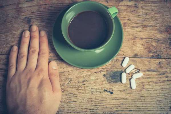 Homme ayant des pilules et du café — Photo