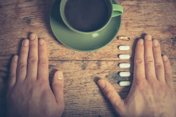 Homem tomando pílulas e café — Fotografia de Stock