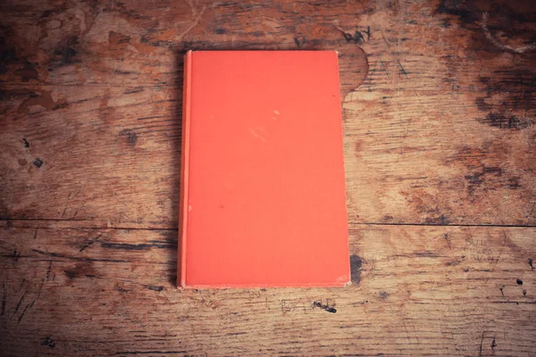 Livro vermelho em uma mesa de madeira — Fotografia de Stock