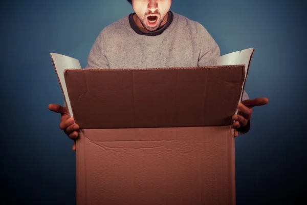 Meglepett a fiatalember izgalmas dobozának kinyitása Stock Kép