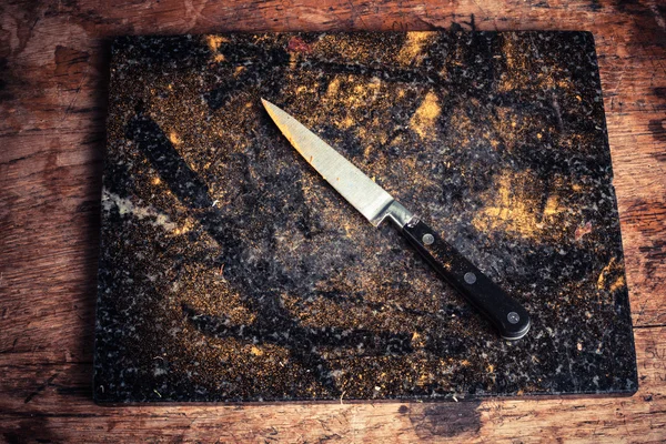 Knife and chopping board covered in spices — Stock Photo, Image