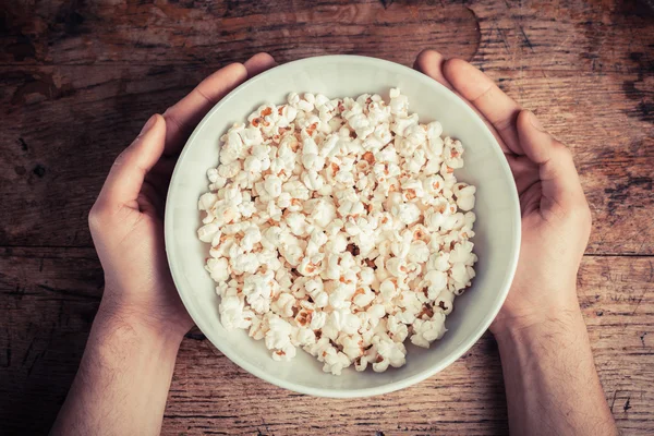 Mani che tengono una ciotola di popcorn — Foto Stock