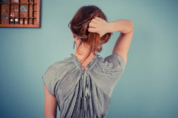 Jovem mulher ajustando seu cabelo — Fotografia de Stock