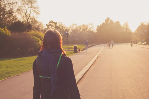 Giovane donna guardando il tramonto nel parco — Foto Stock