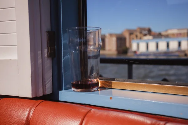 Copo de cerveja por janela em um barco — Fotografia de Stock
