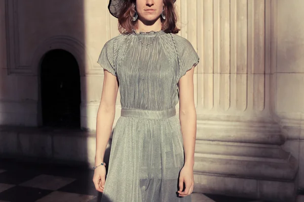 Женщина в элегантном платье стоит в величественном зале — стоковое фото
