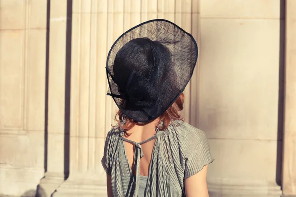 Elegant young woman standing in a grand hall — Stock Photo, Image