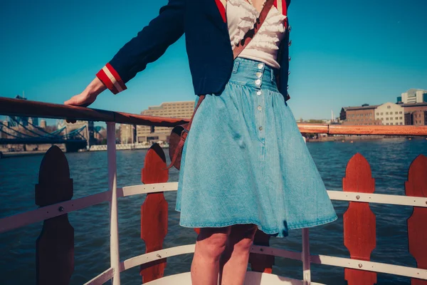 Mujer joven en la cubierta del barco con falda soplando en el viento — Foto de Stock