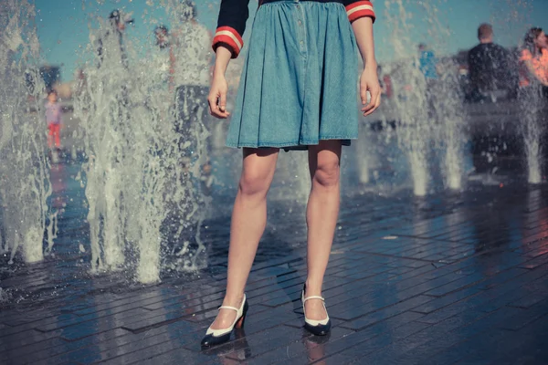 Mujer joven parada junto a la fuente en la ciudad en un día caluroso —  Fotos de Stock