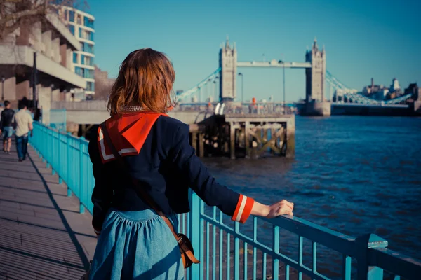 Mujer joven de pie en la orilla del Támesis en Londres — Foto de Stock