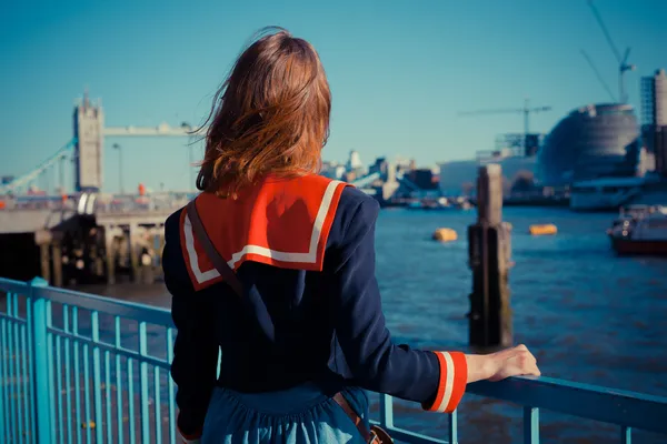 Młoda kobieta stojąc na brzegu Tamizy w Londynie — Zdjęcie stockowe