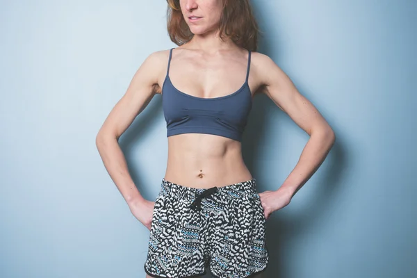Mujer joven con abdominales tonificados en ropa deportiva — Foto de Stock