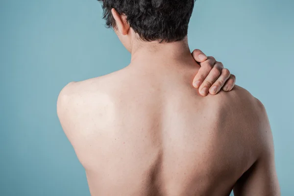 Giovane uomo massaggiare il suo collo dolorante — Foto Stock
