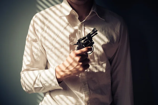 Mannen med pistolen vid fönster — Stockfoto