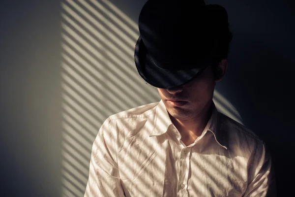 Man in hat next to window — Stock Photo, Image