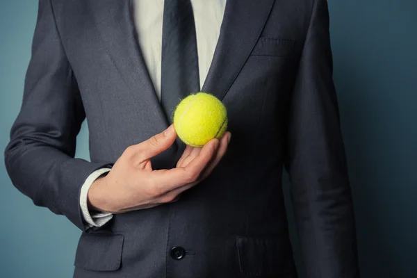 Бизнесмен с теннисным мячом — стоковое фото