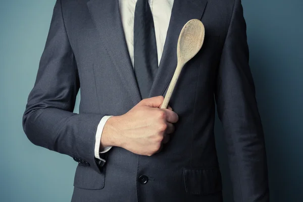 Businessman holding a wooden spoon — Stock Photo, Image