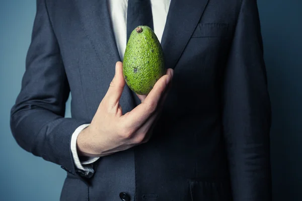 Businesman bedrijf avocado — Stockfoto