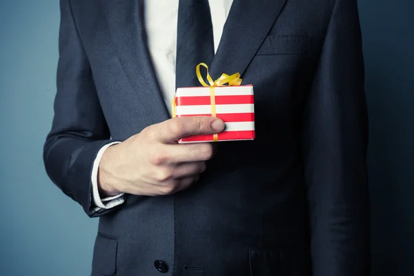 Businessman with small gift — Stock Photo, Image