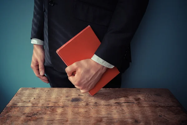 Man with book at desk — Stock Photo, Image