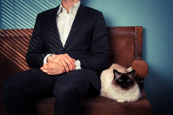 Молодий чоловік і кіт розслабляються на дивані — стокове фото