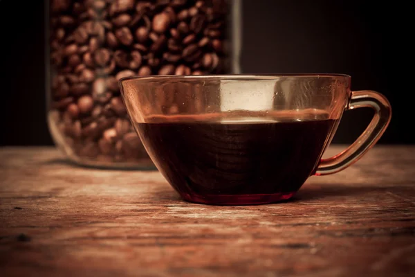 Cup of coffee and jar of beans — Stock Photo, Image