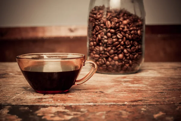 Cup of coffee and jar of beans — Stock Photo, Image
