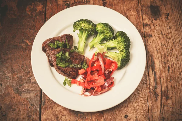 Мясо и овощи на тарелке — стоковое фото