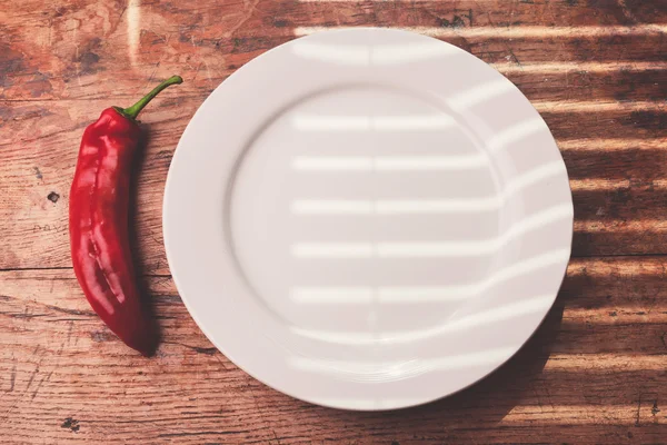 Pimienta roja y un plato — Foto de Stock