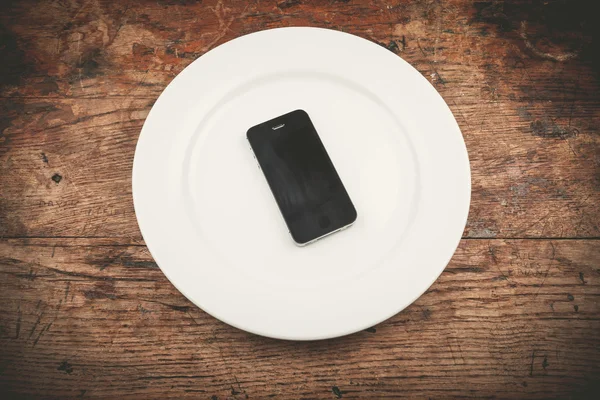 Telefon na białym talerzu — Zdjęcie stockowe