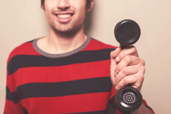 Happy young man holding telephone — Stock Photo, Image